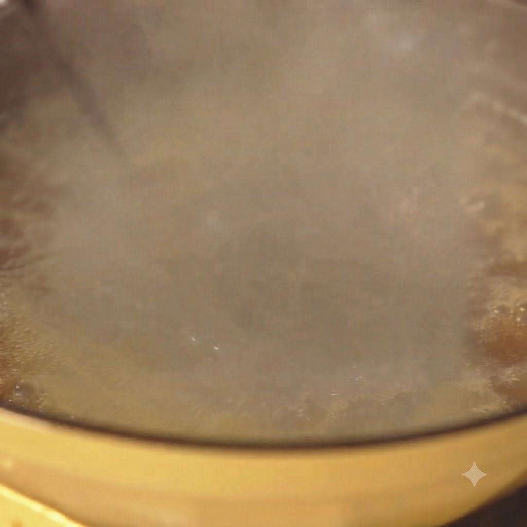 Des spaghetti qui bouillent vigoureusement dans une casserole jaune avec de la vapeur deau.