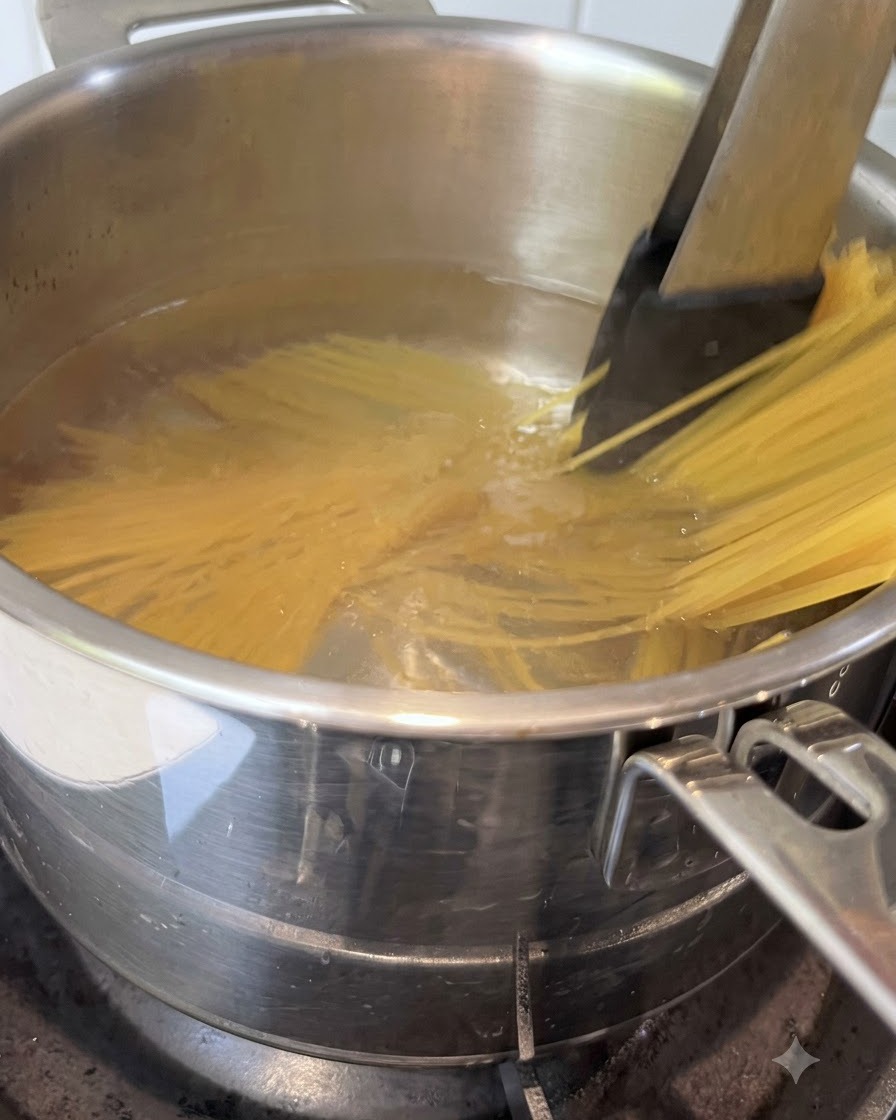 Des spaghettis remués avec des pinces dans une casserole deau bouillante.