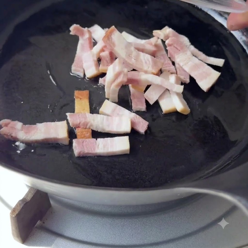 De petits morceaux de bacon ajoutés dans une poêle noire avec de lhuile chaude.