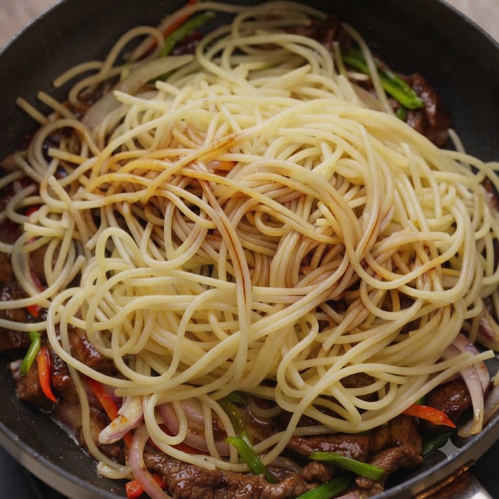 Des sauces versées sur les spaghettis et le bœuf à lintérieur dune poêle.