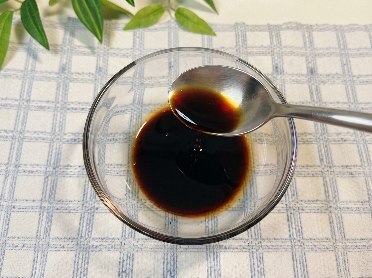 De la sauce soja et dautres assaisonnements mélangés dans un bol en verre avec de leau.