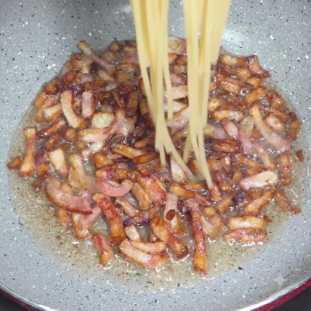 Des spaghettis cuits transférés avec une pince dans une poêle contenant des morceaux de guanciale croustillants.