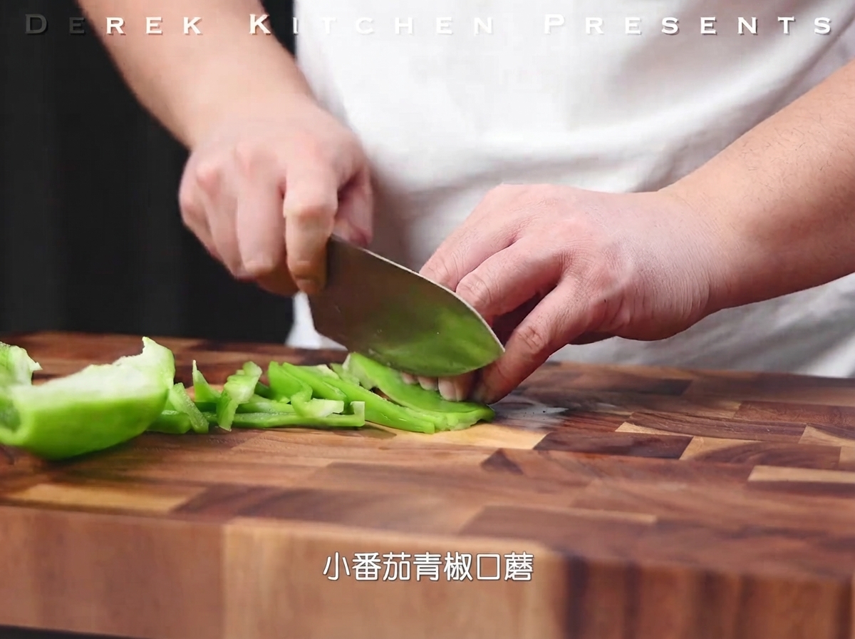 Poivron vert coupé en fines lamelles sur une planche à découper en bois.