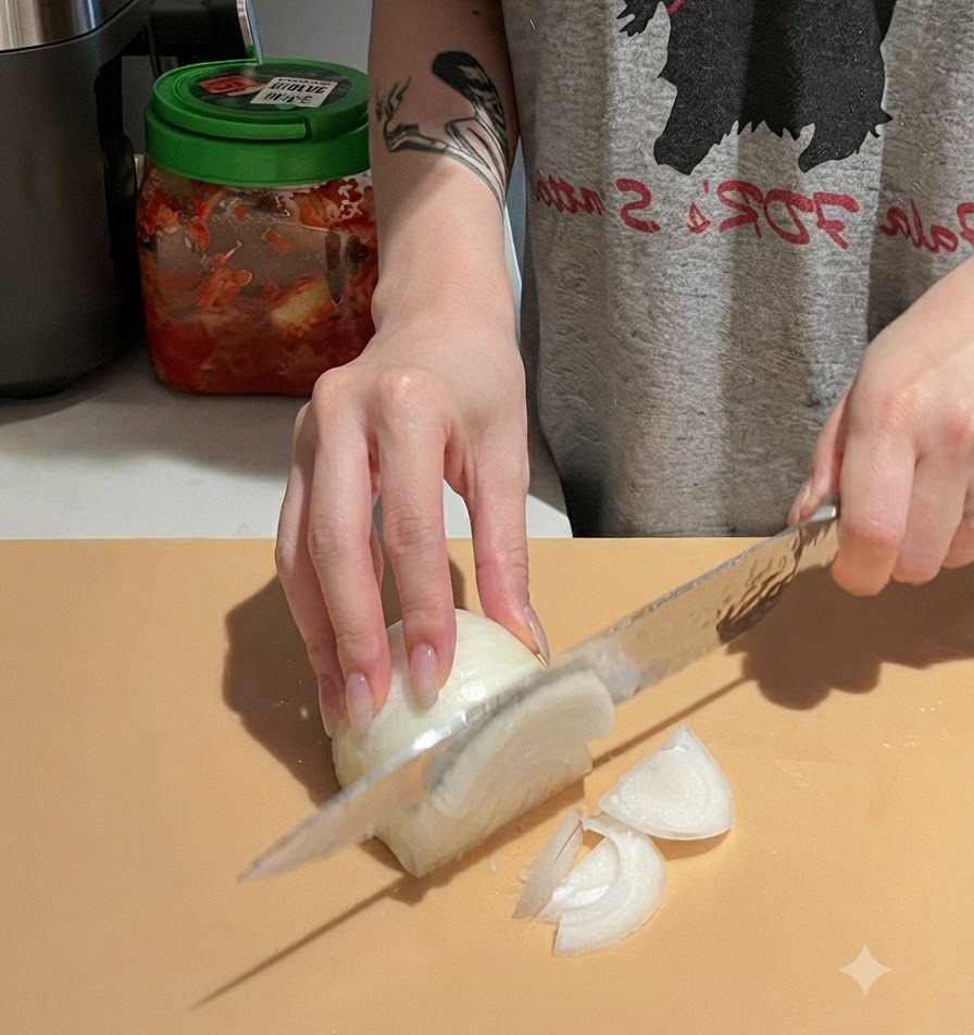 Mains éminçant délicatement un oignon blanc sur une planche à découper avec un couteau de chef.