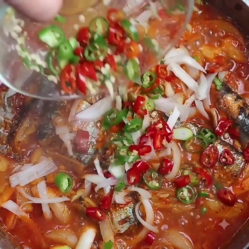 Des tranches de piments rouges et verts versées dun petit bol transparent dans une casserole de saumon-pique braisé frémissant.