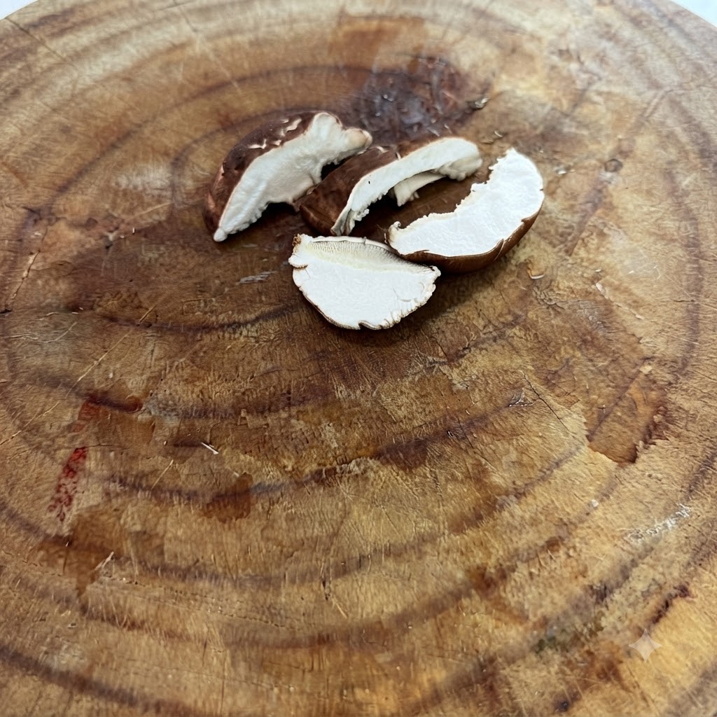 Champignons shiitake frais tranchés finement reposant sur une planche à découper en bois.