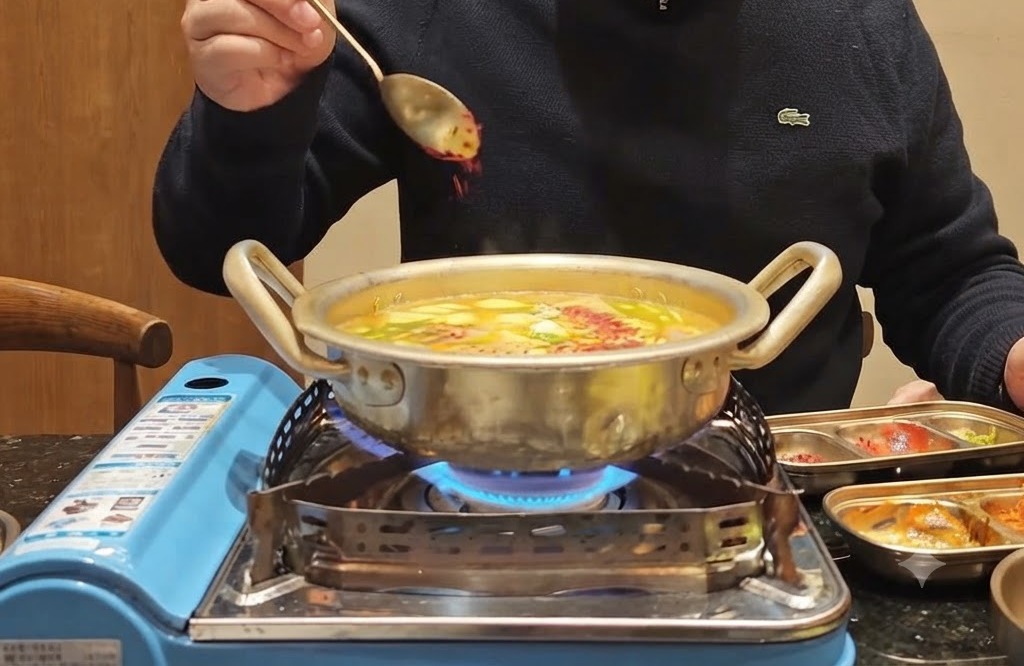 Une cuillère de poudre de piment rouge saupoudrée sur une casserole bouillonnante remplie de légumes et de bouillon.