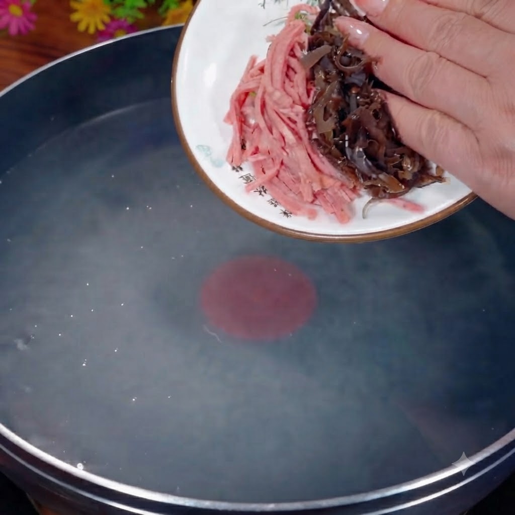 Du fungus noir et du jambon émincés versés dune assiette blanche dans une casserole deau bouillante.