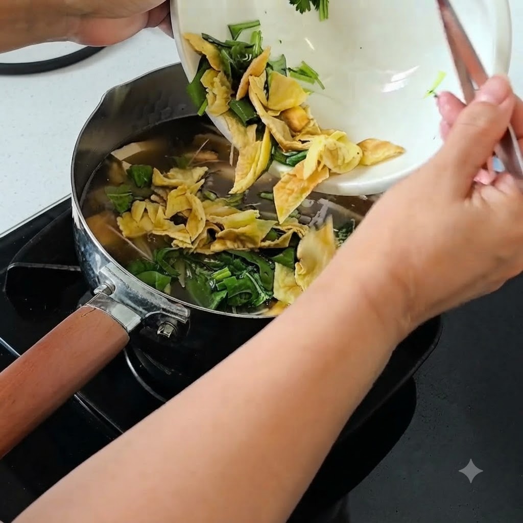 Des ciboules émincées, de la coriandre et de lœuf centenaire haché versés dun bol blanc dans une casserole de soupe frémissante.