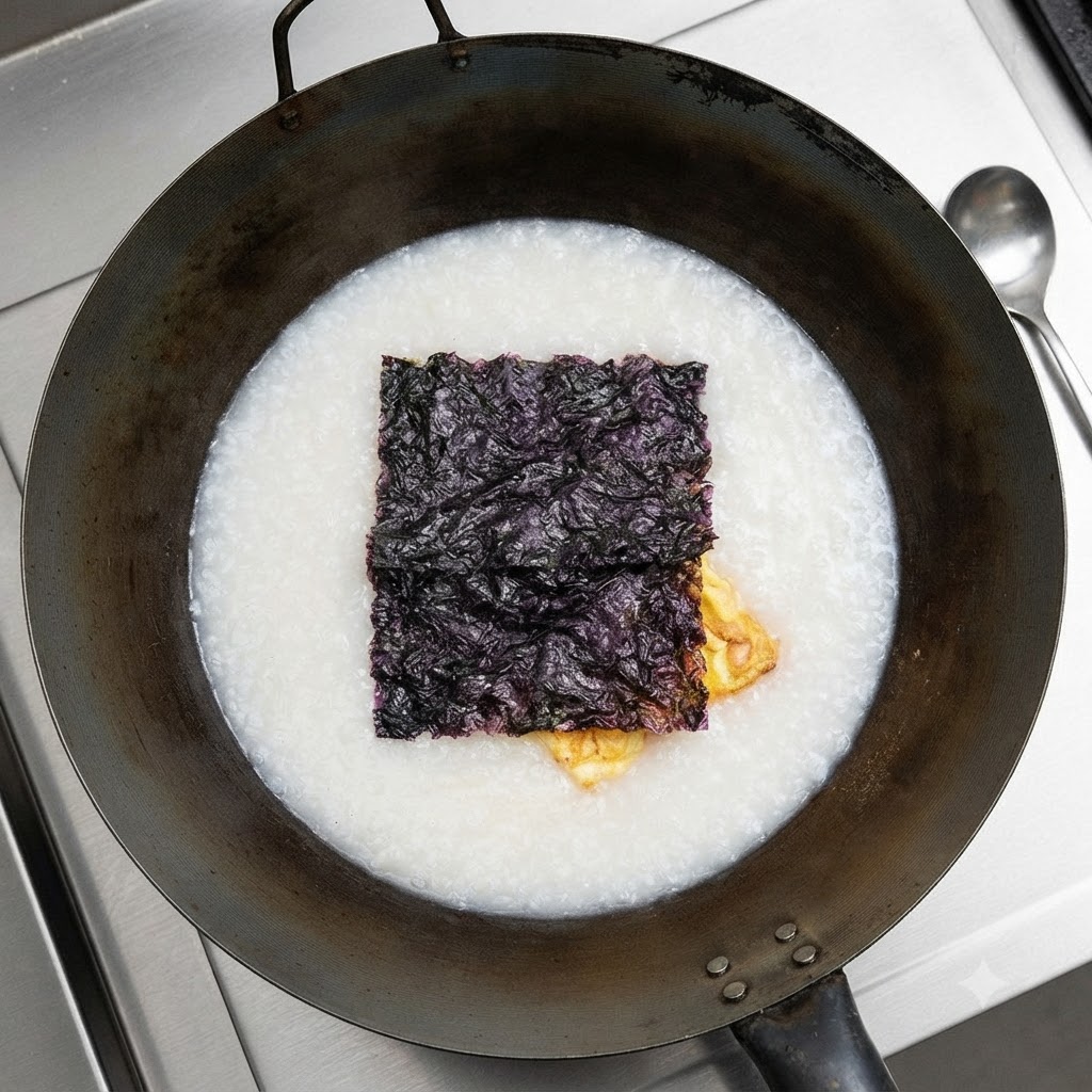 Des algues séchées flottant à la surface de la soupe blanche dans le wok.
