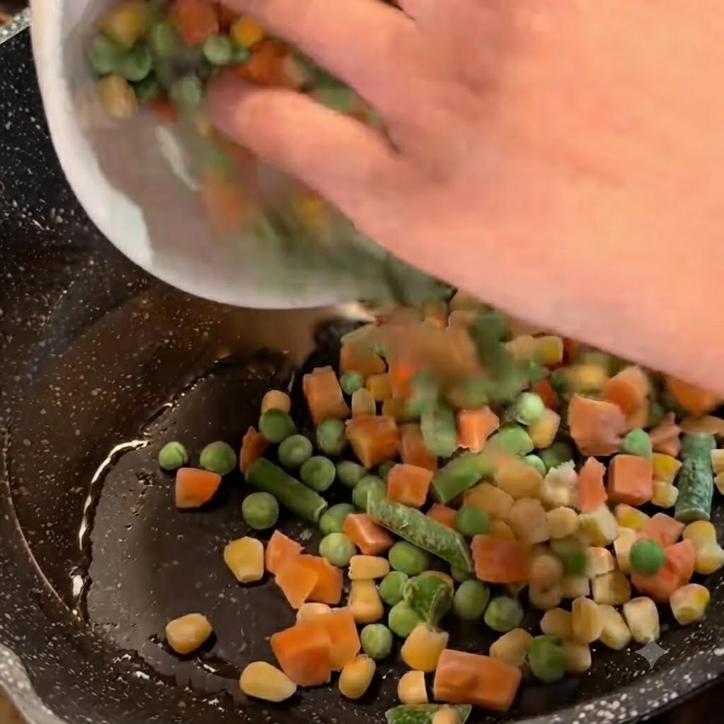 Légumes mélangés surgelés versés dun bol blanc dans une poêle contenant de lhuile et de la ciboulette.