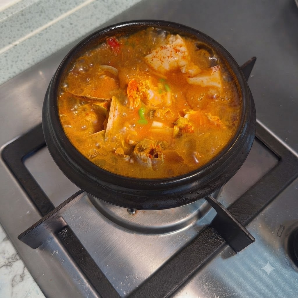 Ragoût coréen piquant au tofu soyeux garni doignons verts hachés dans un pot en pierre chaud.