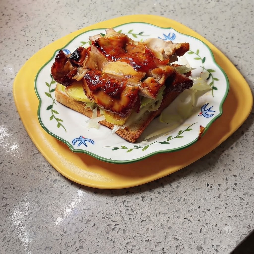 Un sandwich terminé au poulet teriyaki et à lananas dressé sur un plateau jaune, prêt à être saucé et servi.