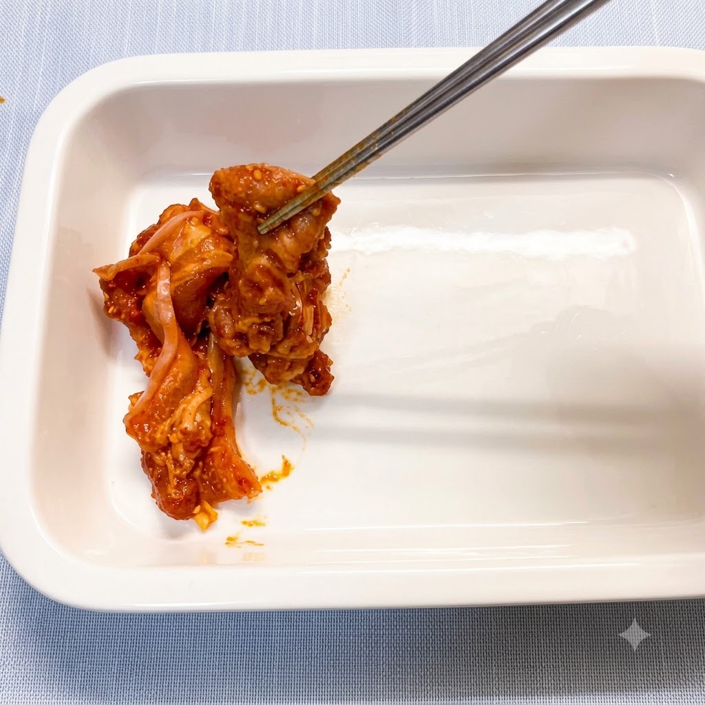 Tranches de poitrine de porc marinées placées individuellement dans un plat de cuisson en céramique blanche propre avec des baguettes.