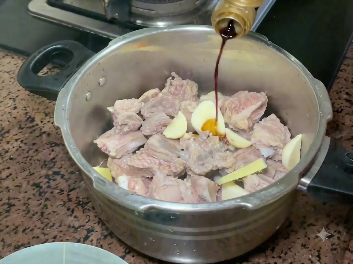 Sauce soja claire versée dune bouteille sur les travers de porc et les aromatiques dans lautocuiseur.