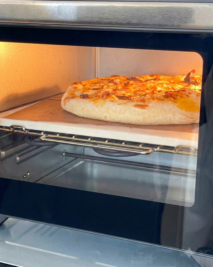 Une pizza dorée au fromage fondu cuisant dans un petit four sur une pierre.