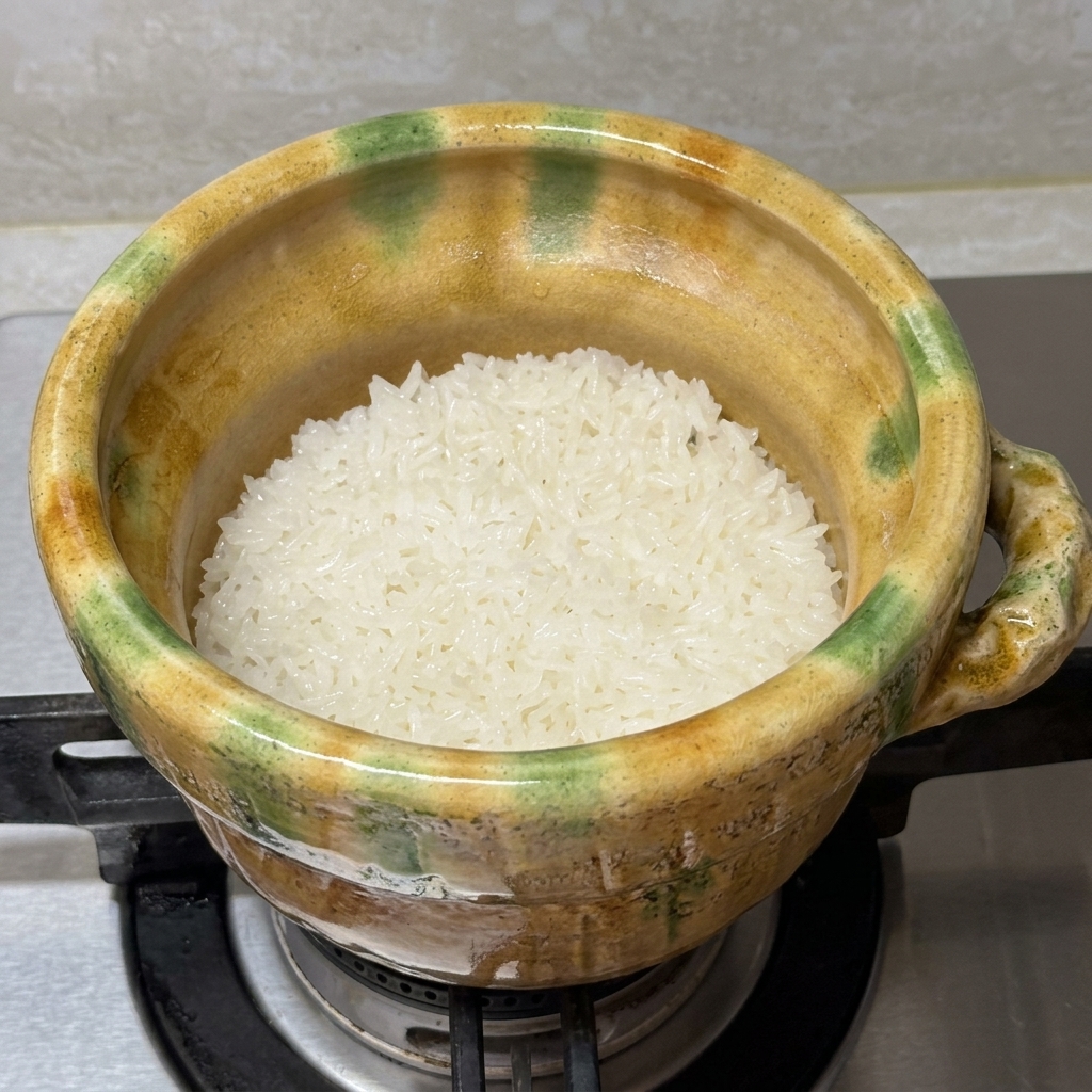 Un filet de saumon saisi placé dans la cocotte sur le riz en train de cuire.
