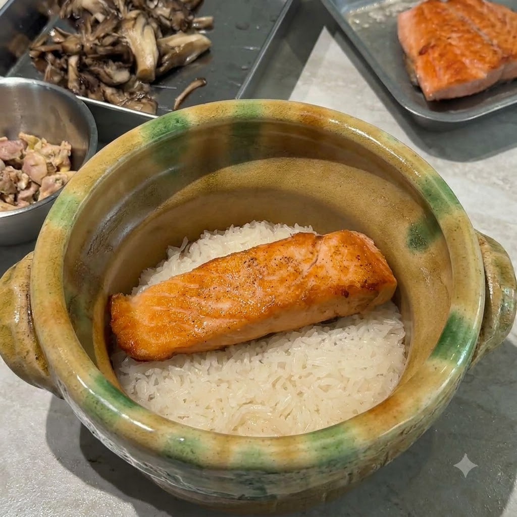 Des champignons maitake sautés et dorés disposés sur le saumon et le riz à lintérieur de la cocotte.