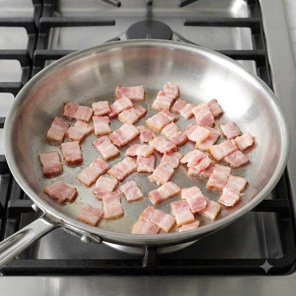 Morceaux de bacon en dés grésillant et brunissant dans une poêle chaude en acier inoxydable.