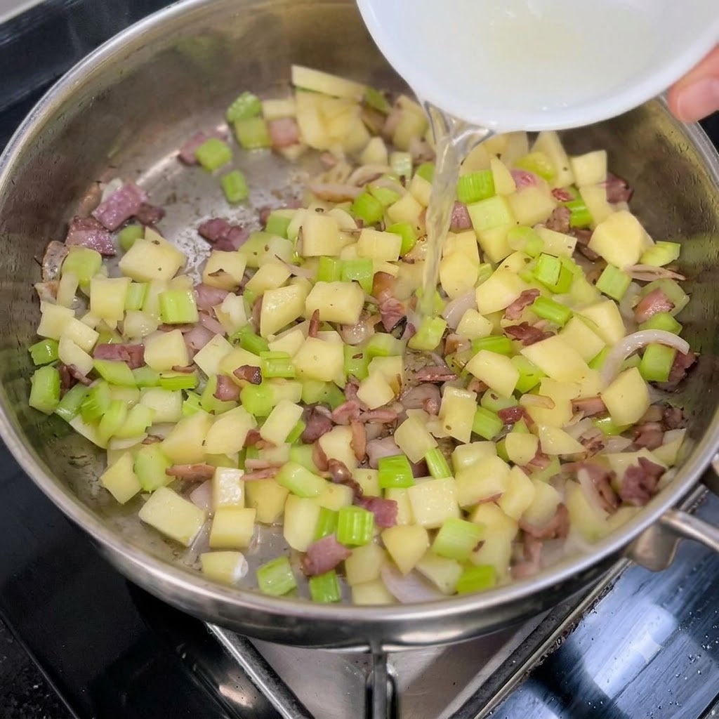Bouillon de palourdes clair versé dun bol blanc dans une poêle de légumes sautés et de bacon.