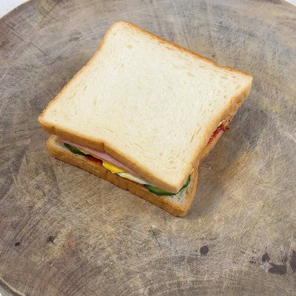 Une fourchette étalant la mayonnaise en douceur sur une tranche de pain toasté doré.