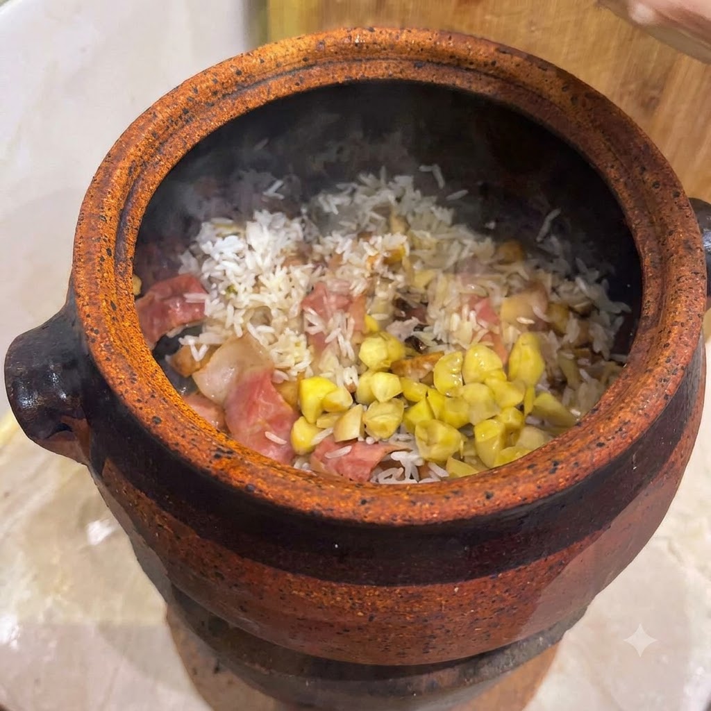 Noix de ginkgo et morceaux de châtaignes jaunes éparpillés sur un fond de riz et de bacon mélangés à lintérieur dune cocotte en argile.