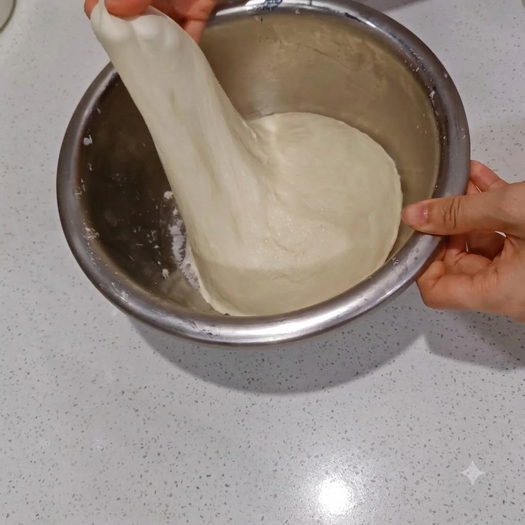 Étirage de la pâte infusée deau pour montrer une fine couche de membrane translucide.
