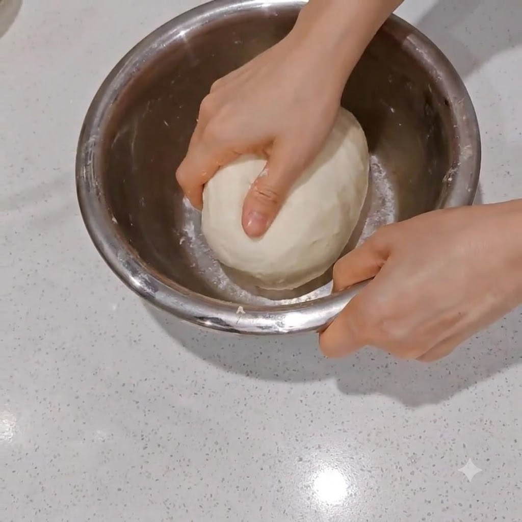Une boule de pâte lisse divisée en deux moitiés égales à laide dun racloir à pâte en métal.