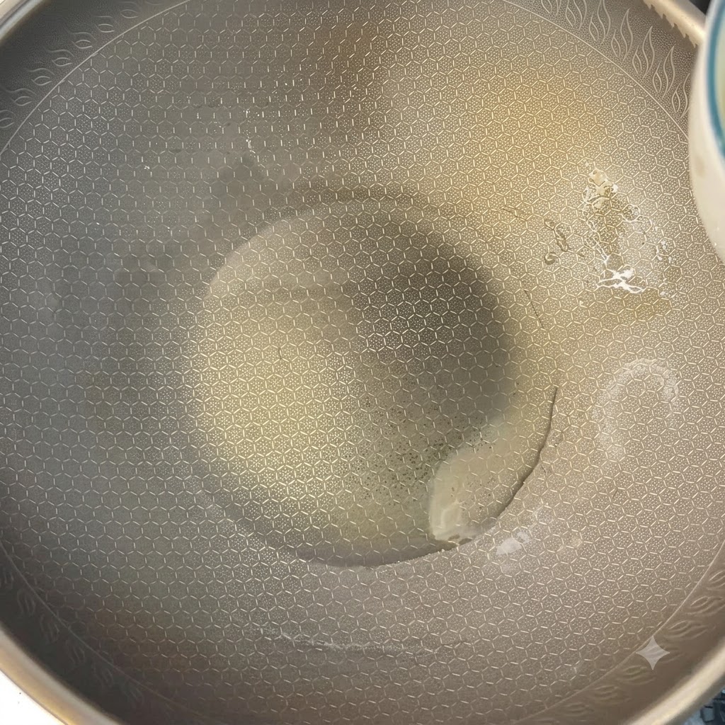 Des œufs battus en train de cuire dans un wok chaud à laide de baguettes.