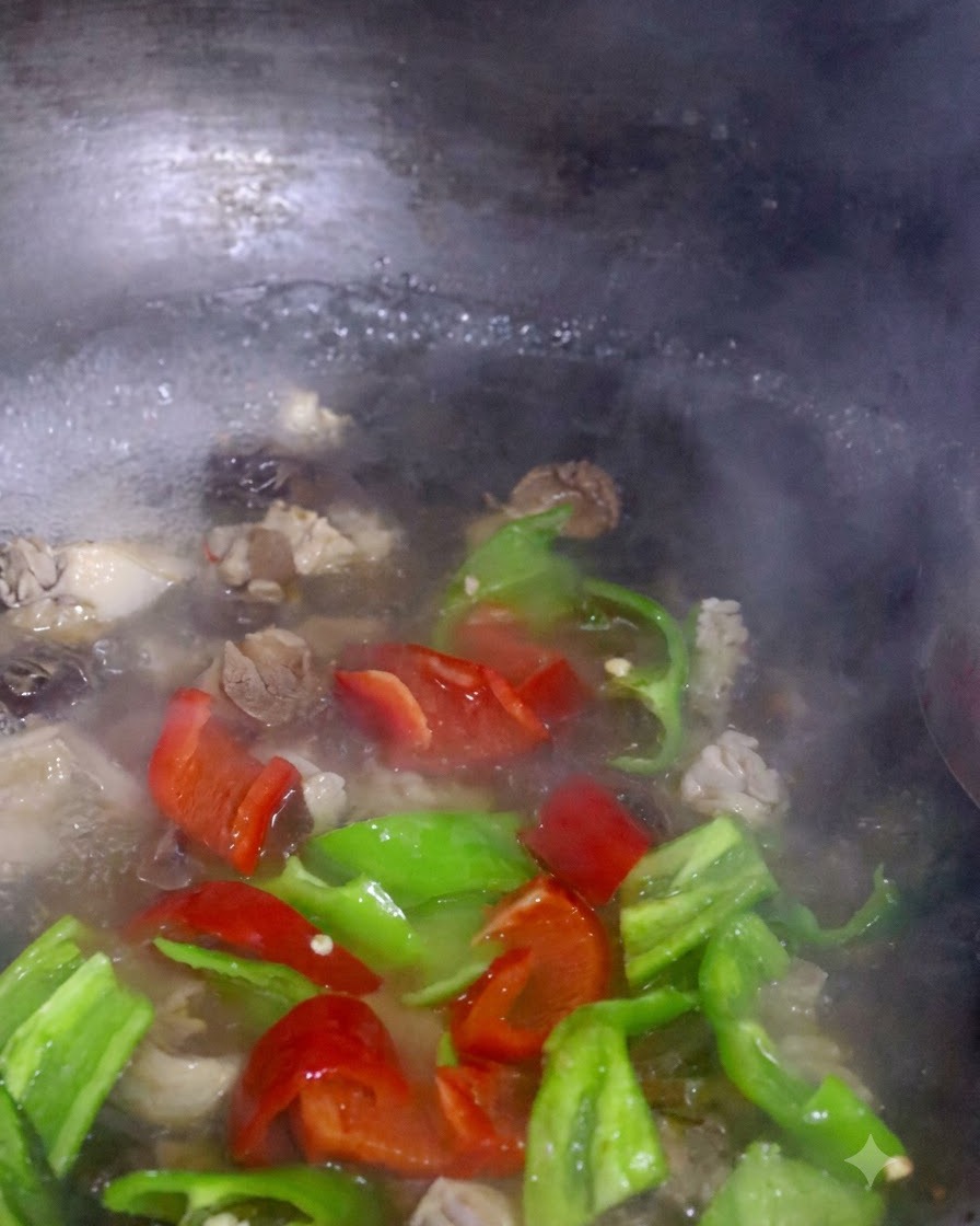 Des tranches de poivrons rouges et verts et du pak choi bouillant ensemble avec les champignons dans une casserole.