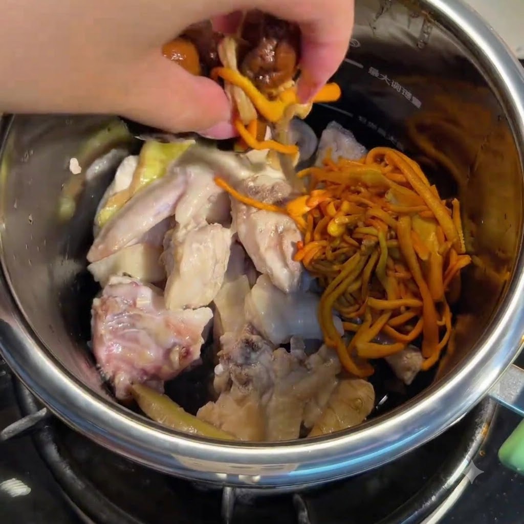 Main ajoutant des champignons trempés et des fleurs de cordyceps dans le pot avec le poulet.