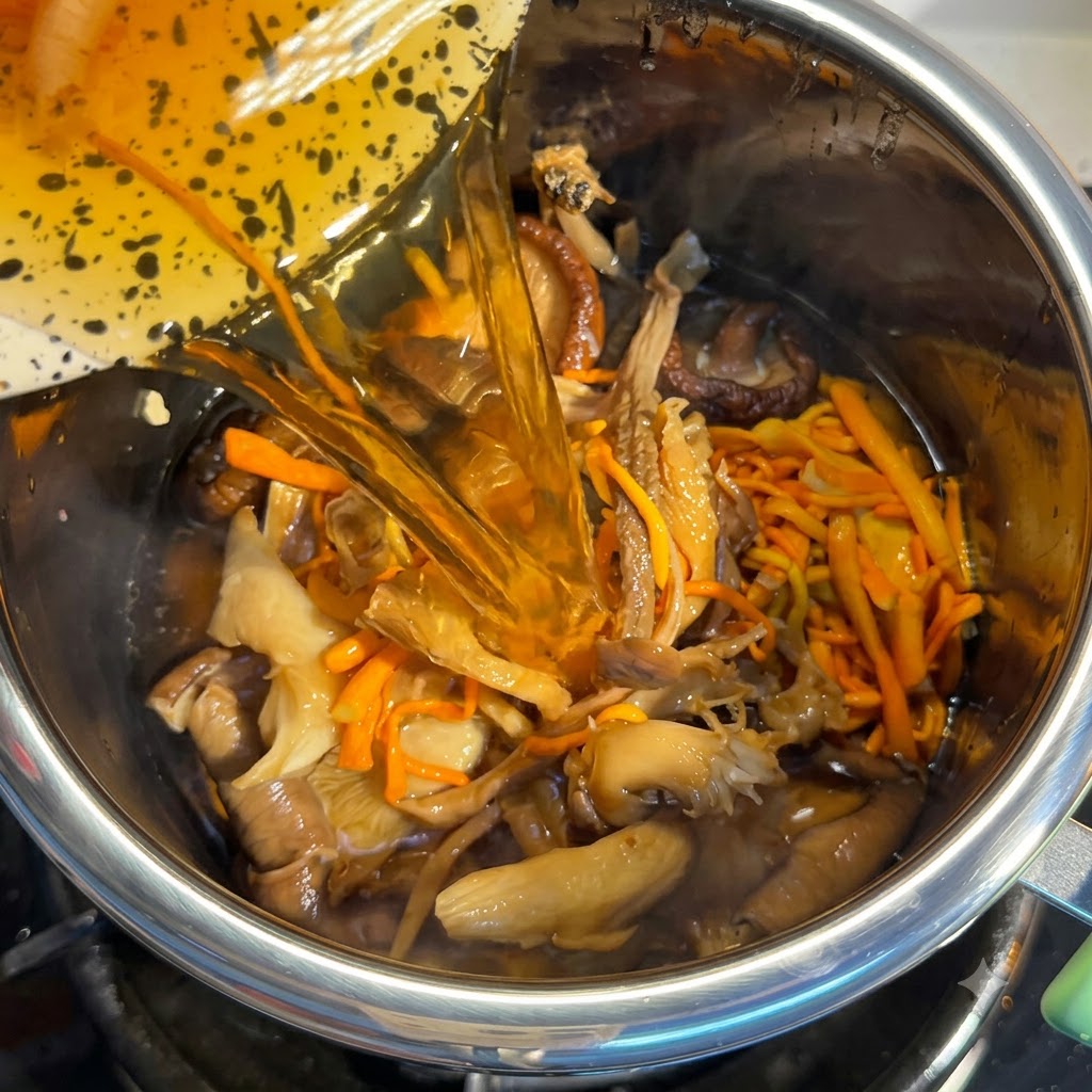Eau de trempage des champignons versée dans le pot rempli dingrédients.