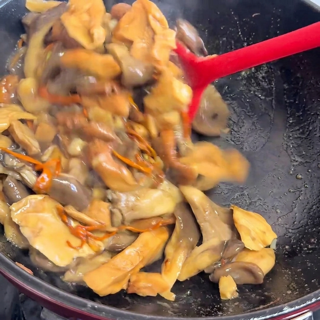 Du liquide versé dans la poêle sur les champignons cuits.