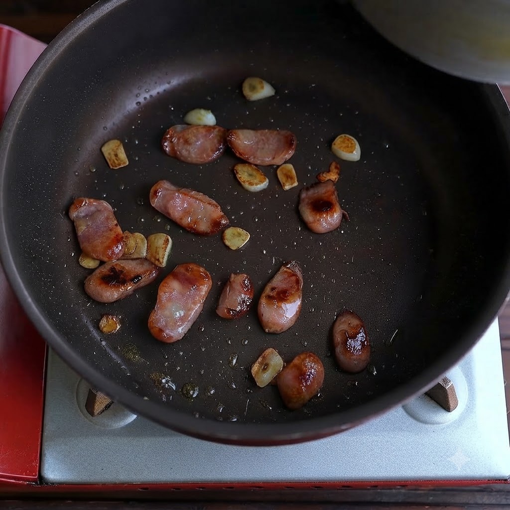 Des saucisses cuites et des morceaux dail frit éparpillés au fond dune poêle.