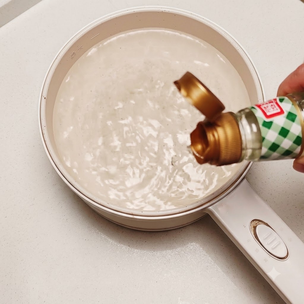 Un œuf cru comestible jeté dans une casserole deau chaude tourbillonnante avec un peu de vinaigre de riz.