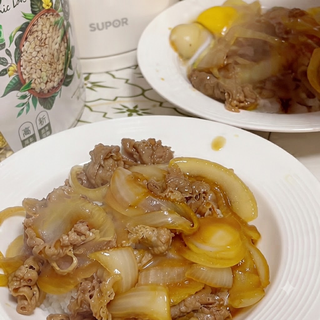Une assiette finie de bœuf et doignons sur du riz, avec un jaune dœuf cru au centre dans un petit creux.