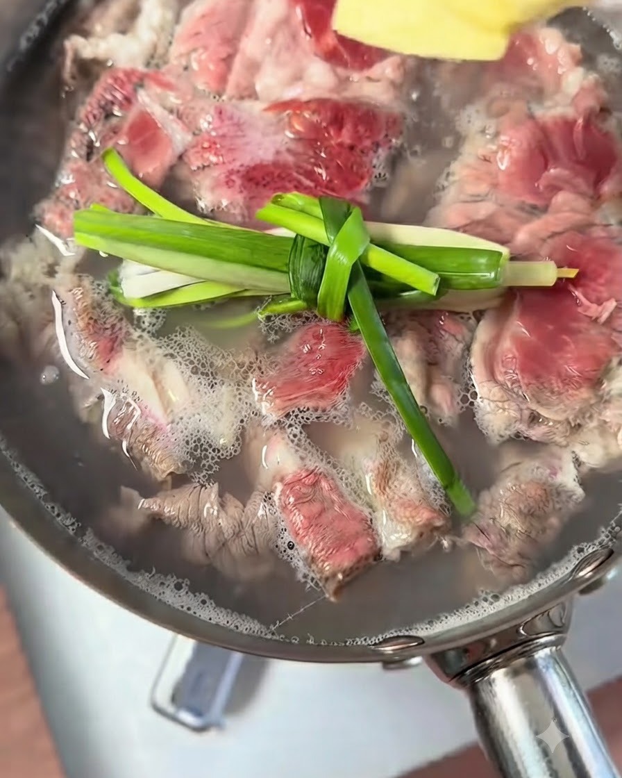 Des nœuds de ciboule et des morceaux de gingembre flottant dans leau de cuisson du bœuf.
