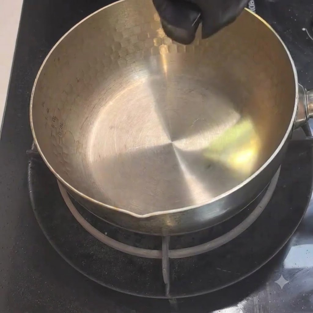 De lhuile de cuisson versée depuis un petit contenant dans une casserole en métal chauffée sur la cuisinière.