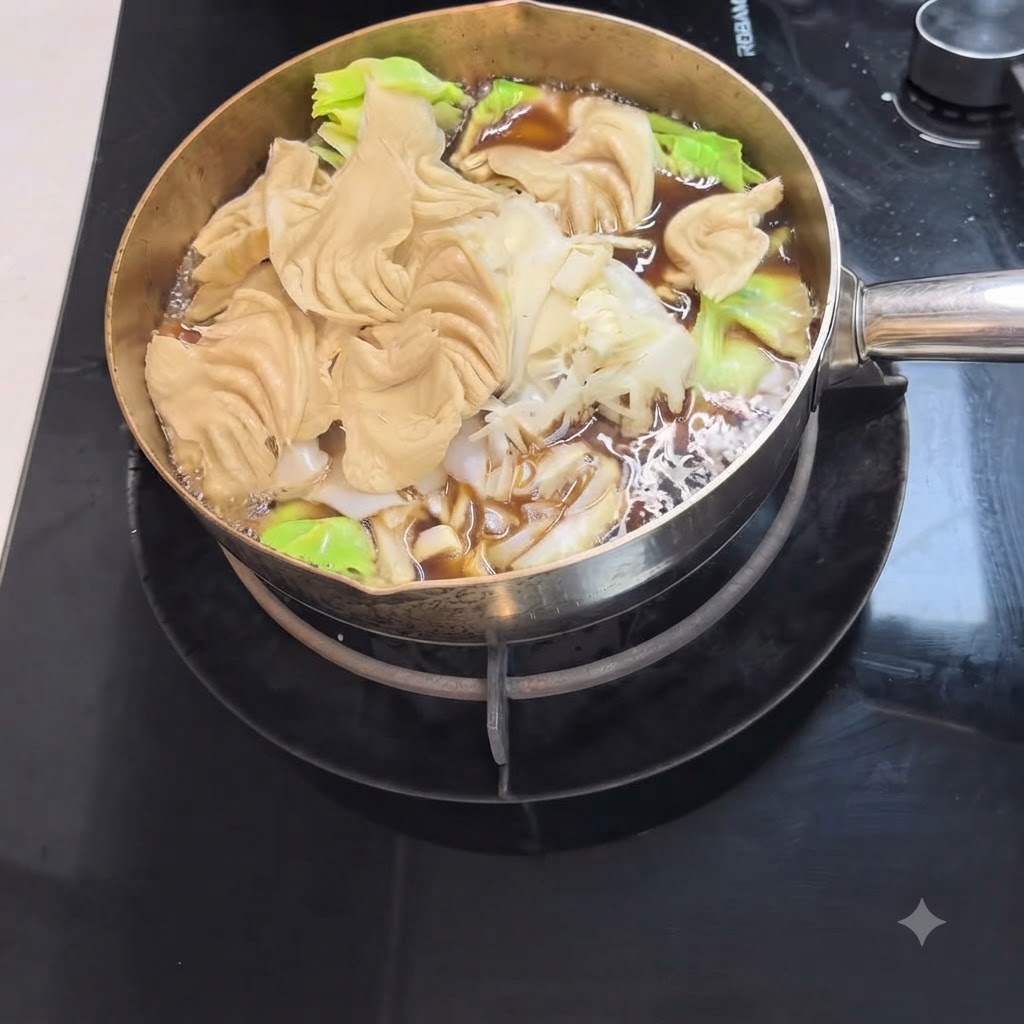 Des nouilles udon et des légumes verts frais mijotant dans une casserole de bouillon sukiyaki foncé.