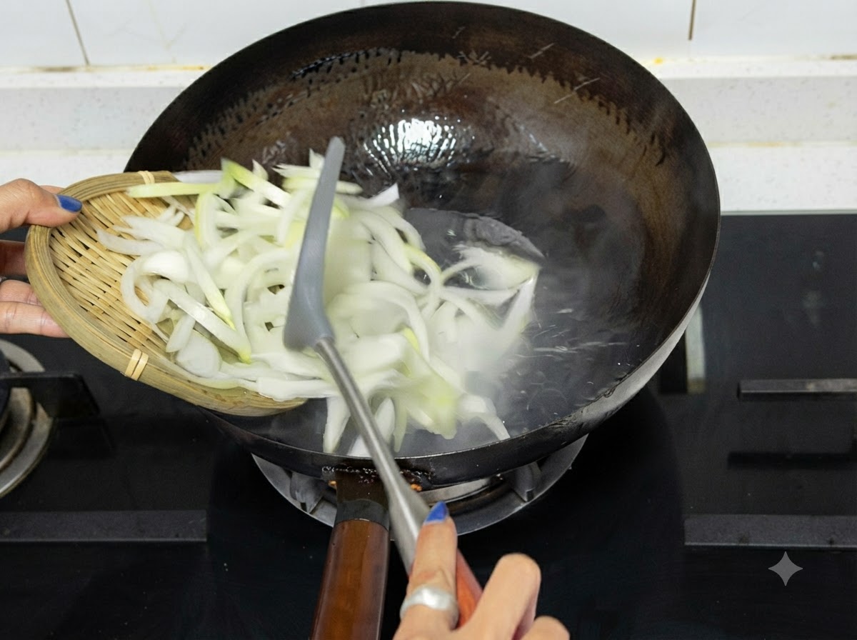 Des oignons émincés versés depuis un plateau en bois dans un wok chaud sur une plaque de cuisson.