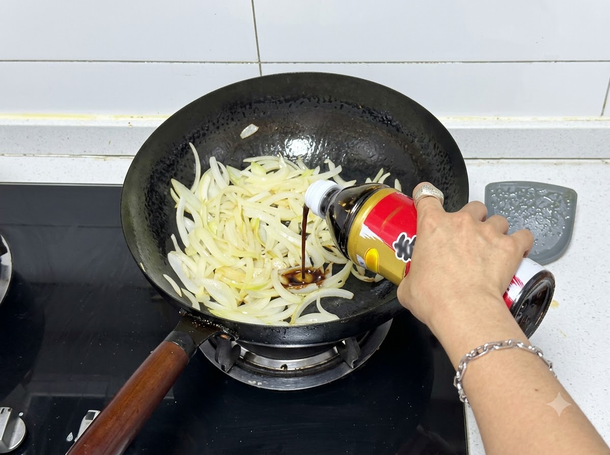 De la sauce sukiyaki versée à partir dune bouteille dans un wok rempli doignons sautés.