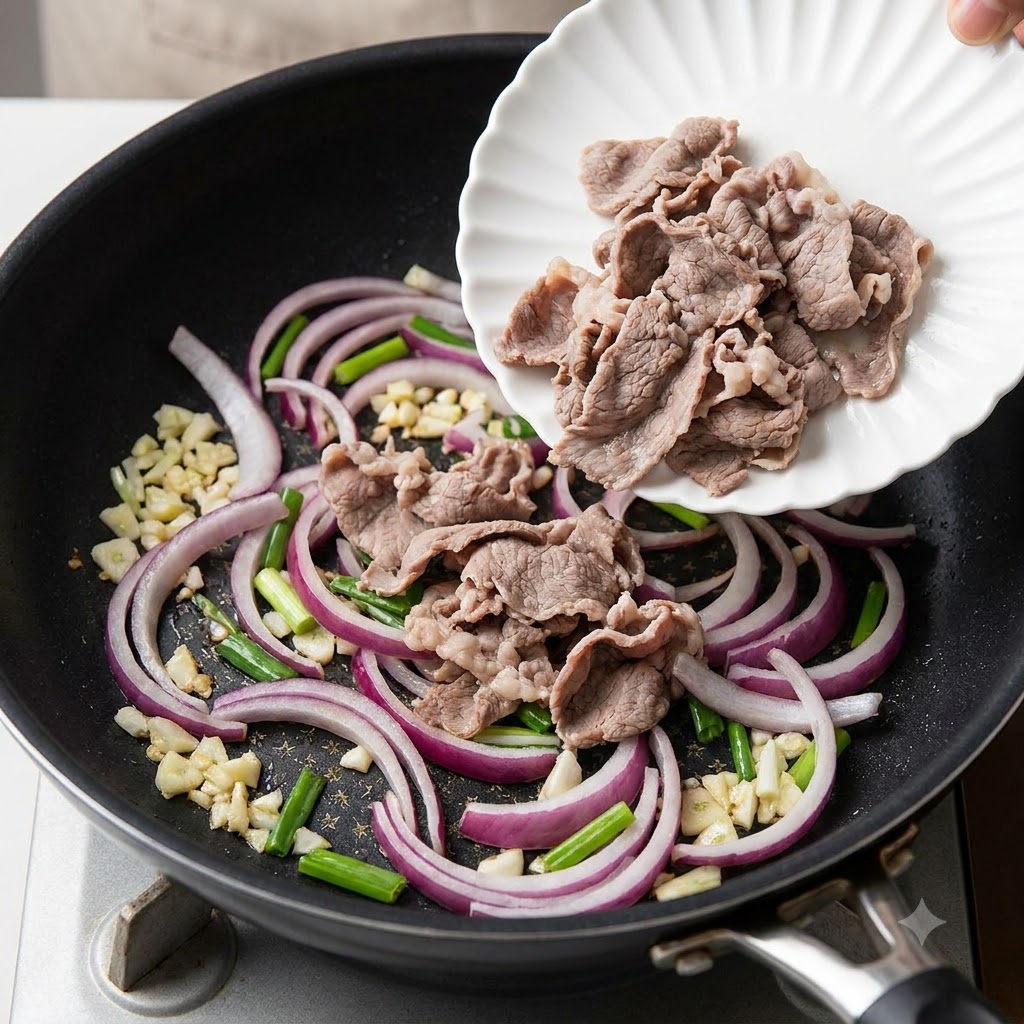 Des rouleaux de bœuf tranchés et blanchis transférés dune assiette blanche vers une poêle contenant des tranches doignon rouge sautées.