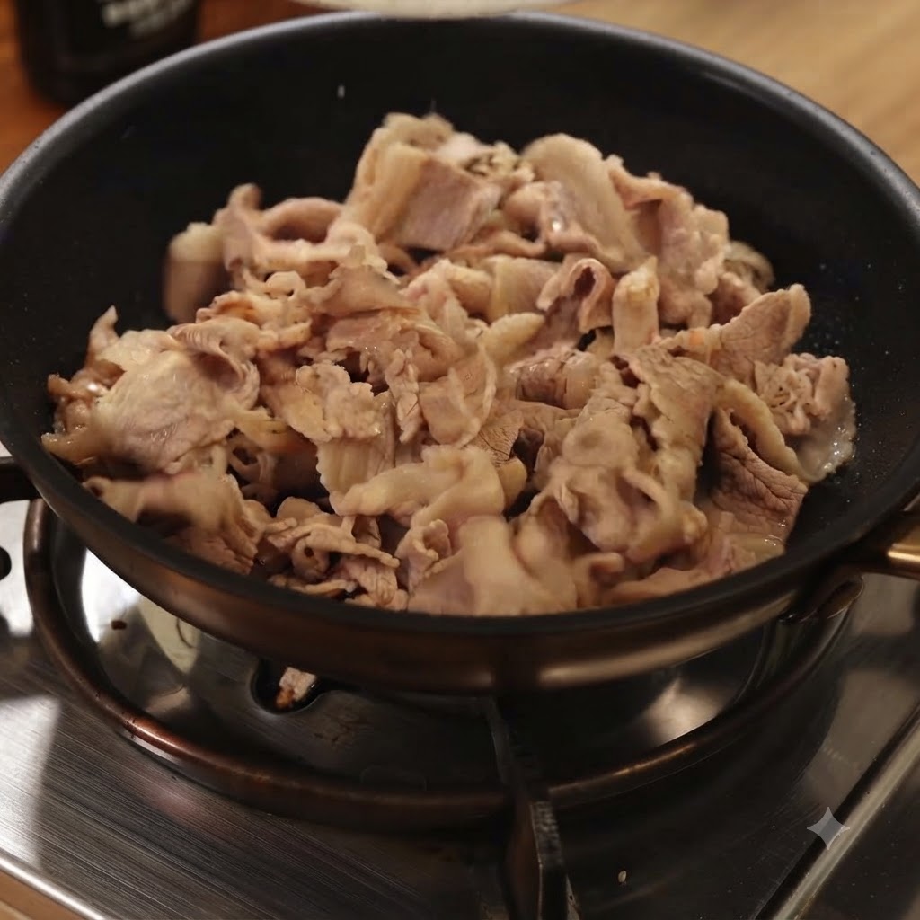 Tranches de bœuf blanchies en train dêtre sautées dans une poêle noire sur une cuisinière à gaz.