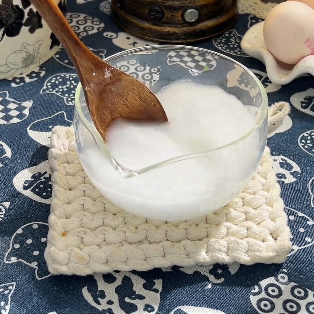Une cuillère en bois mélangeant de la sauce soja, de la sauce huître et du miel dans le mélange de fécule de maïs.