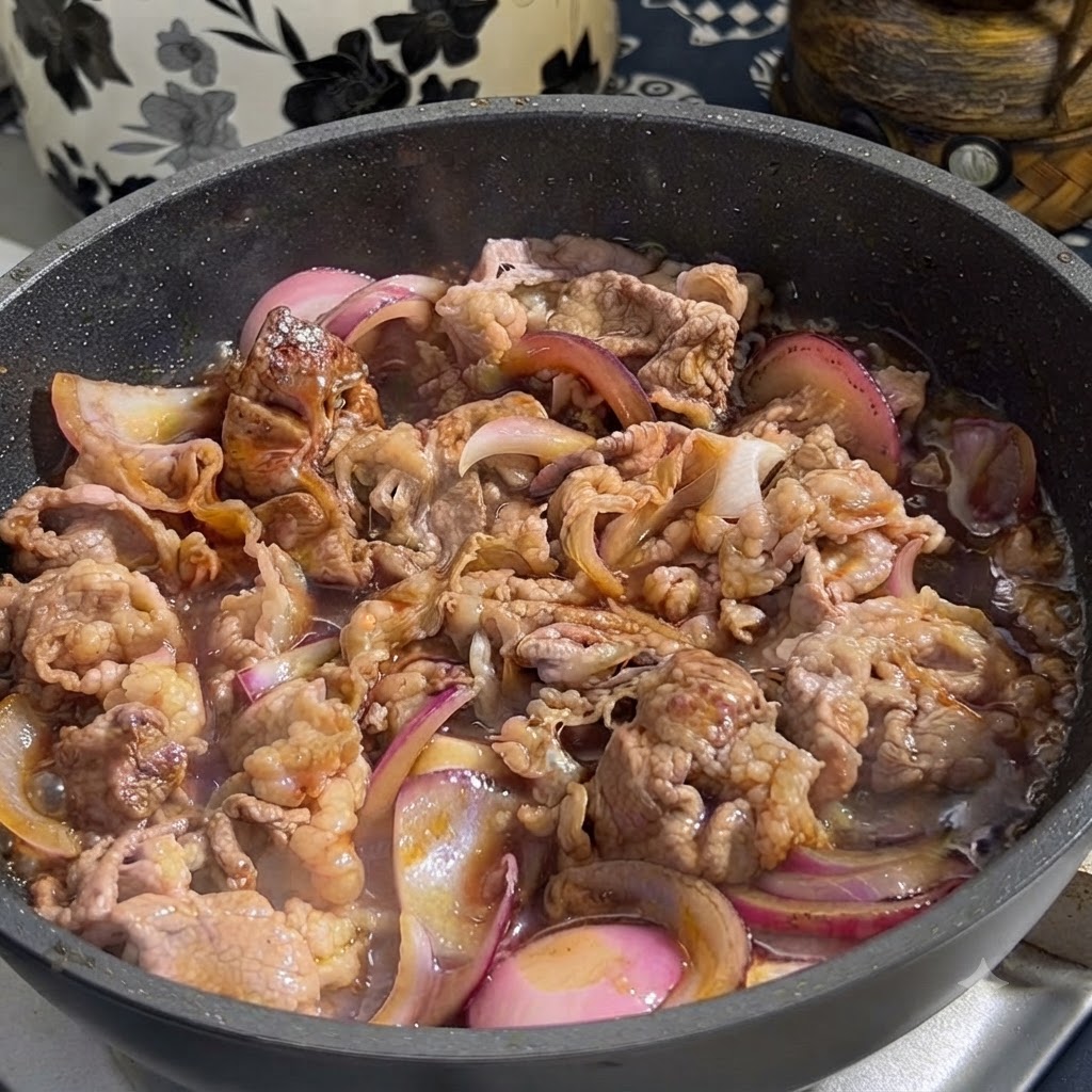 Sauce teriyaki versée à partir dun récipient dans une poêle contenant du bœuf doré et des oignons rouges tranchés.