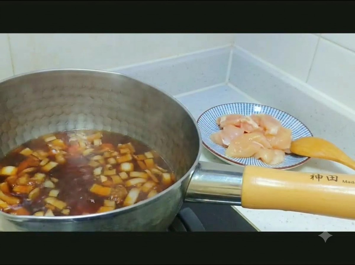 Du poulet en des cru et des oignons eminces transferes dune assiette a motifs dans une casserole de bouillon fonce.