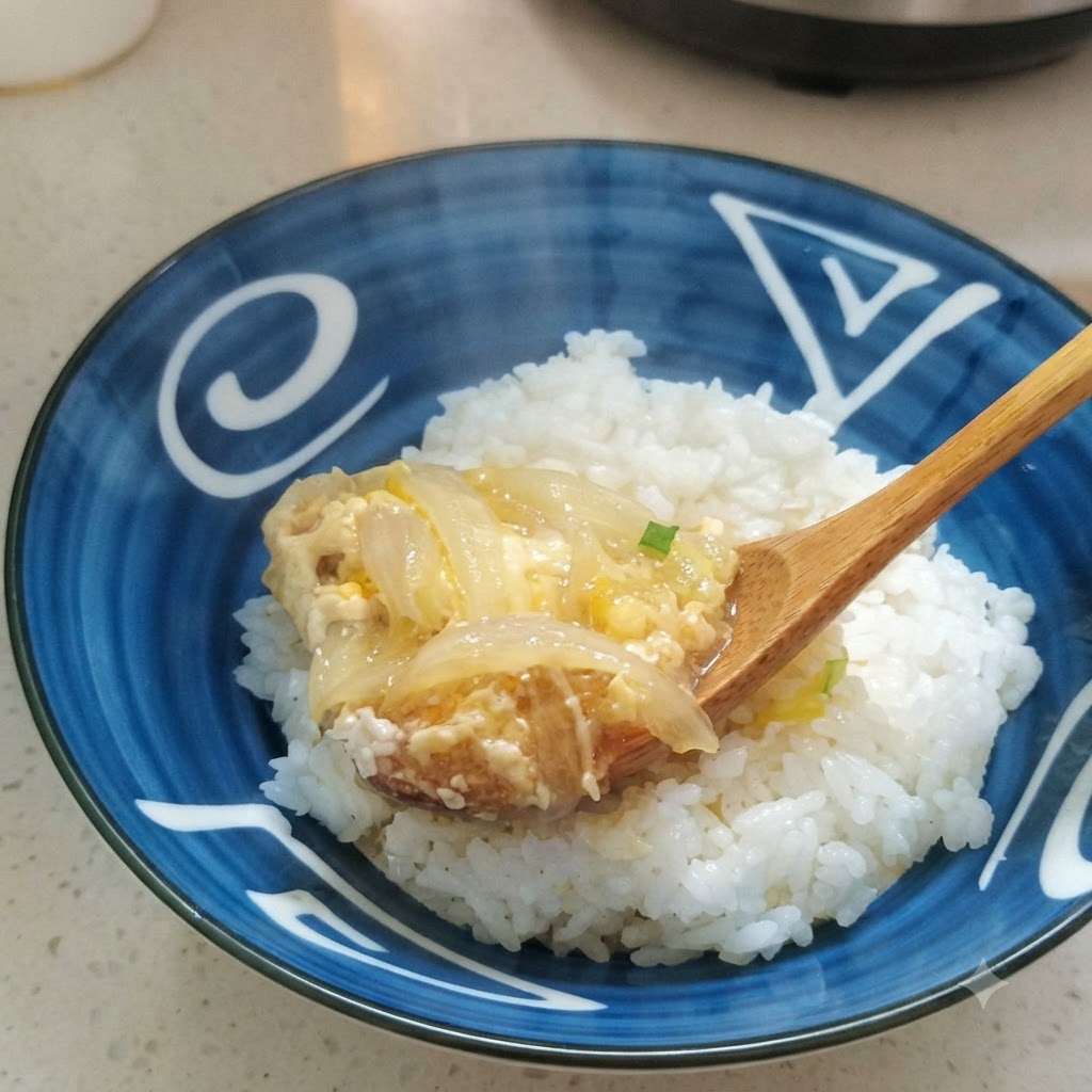 Le melange de poulet, doeuf et doignon cuit servi sur un bol de riz blanc.