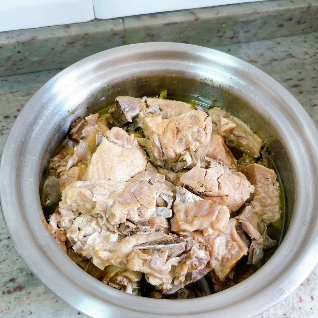 Le couvercle de lautocuiseur est retiré, montrant la viande de canard cuite submergée dans un riche bouillon.