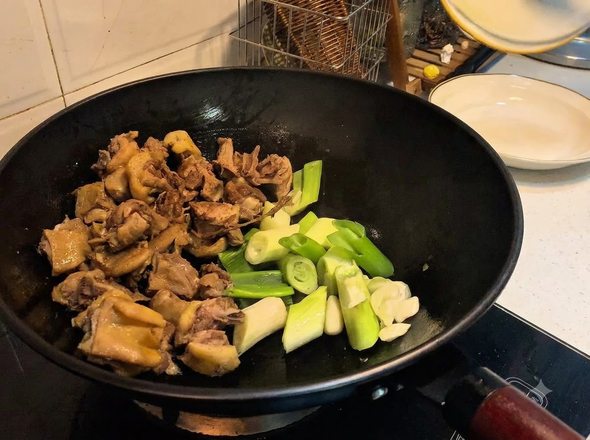 Ciboulettes, ail, gingembre et épices ajoutés dans le wok aux côtés du canard.