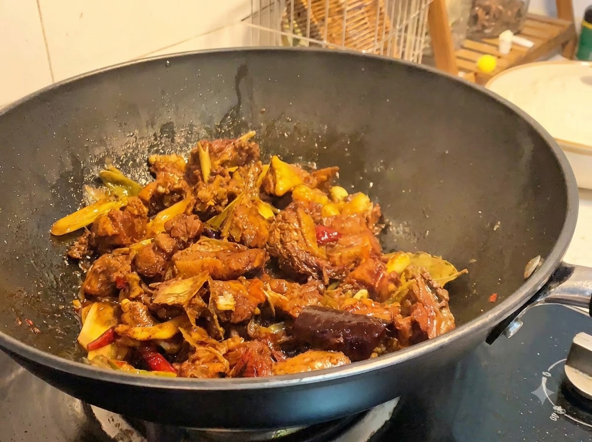 Morceaux de canard braisés cuisant dans un wok à feu vif tandis que la sauce réduit et sépaissit.